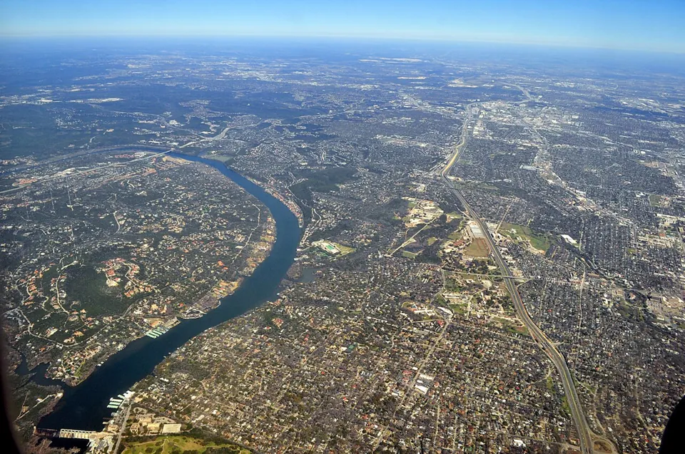 Aerial view of the Colorado River beside the wooded neighborhoods of West Lake Hills