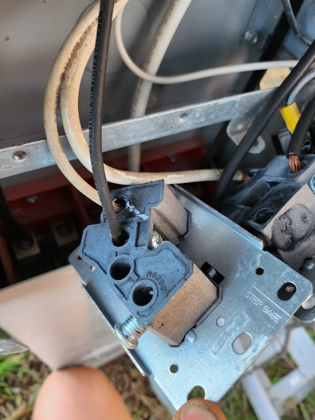 Electrical receptacle and wiring removed from a metal enclosure.