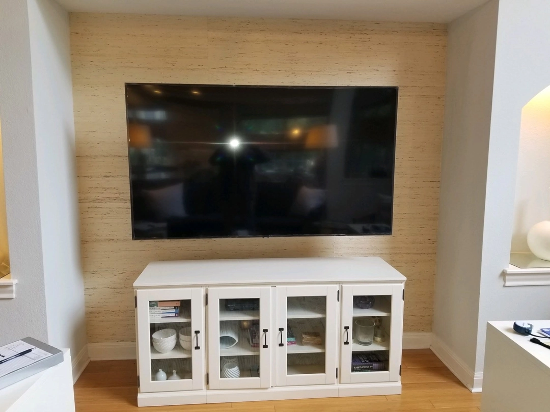 Wall-mounted television above a cabinet in a recessed alcove.