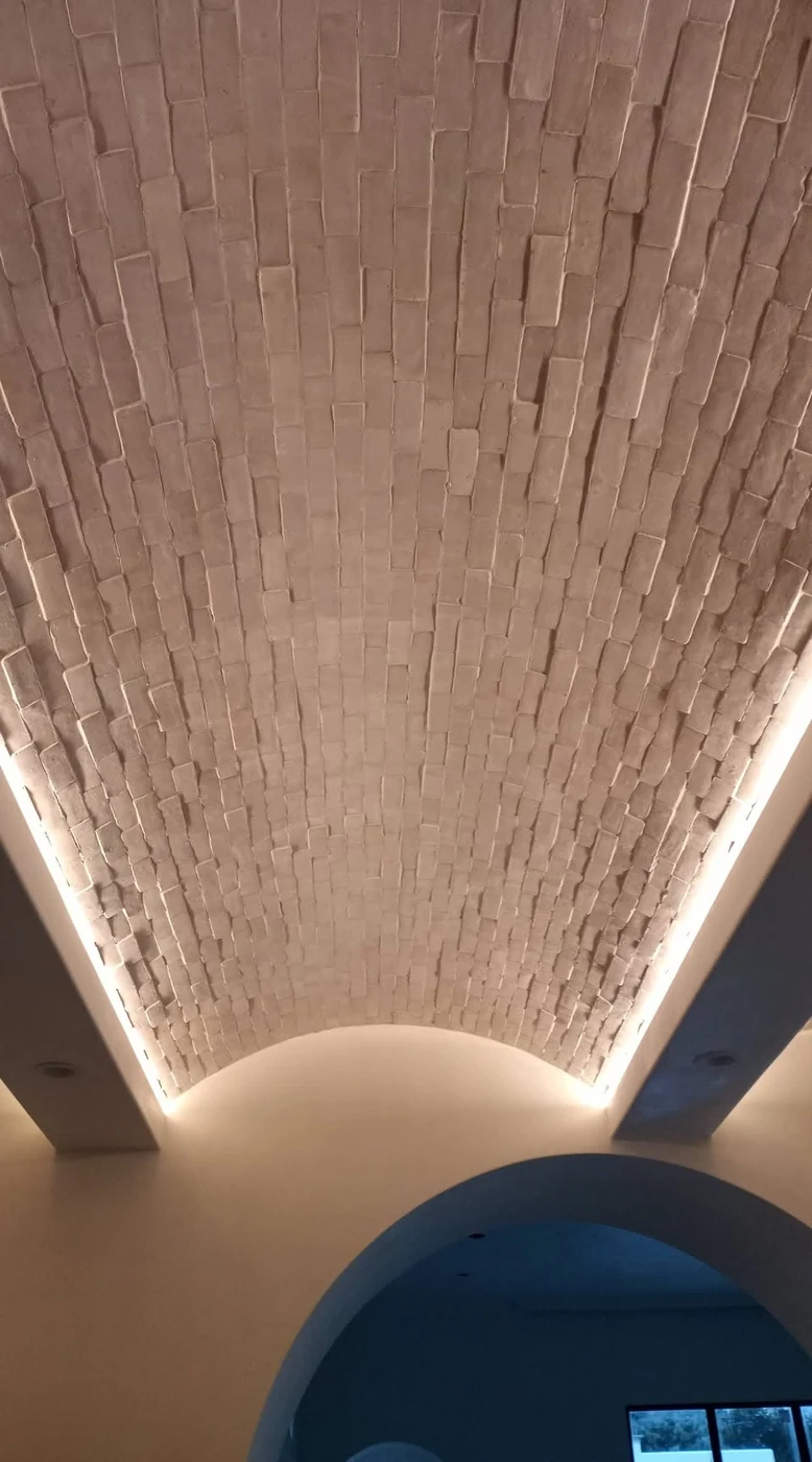 Warm cove lighting along the edges of a vaulted ceiling.
