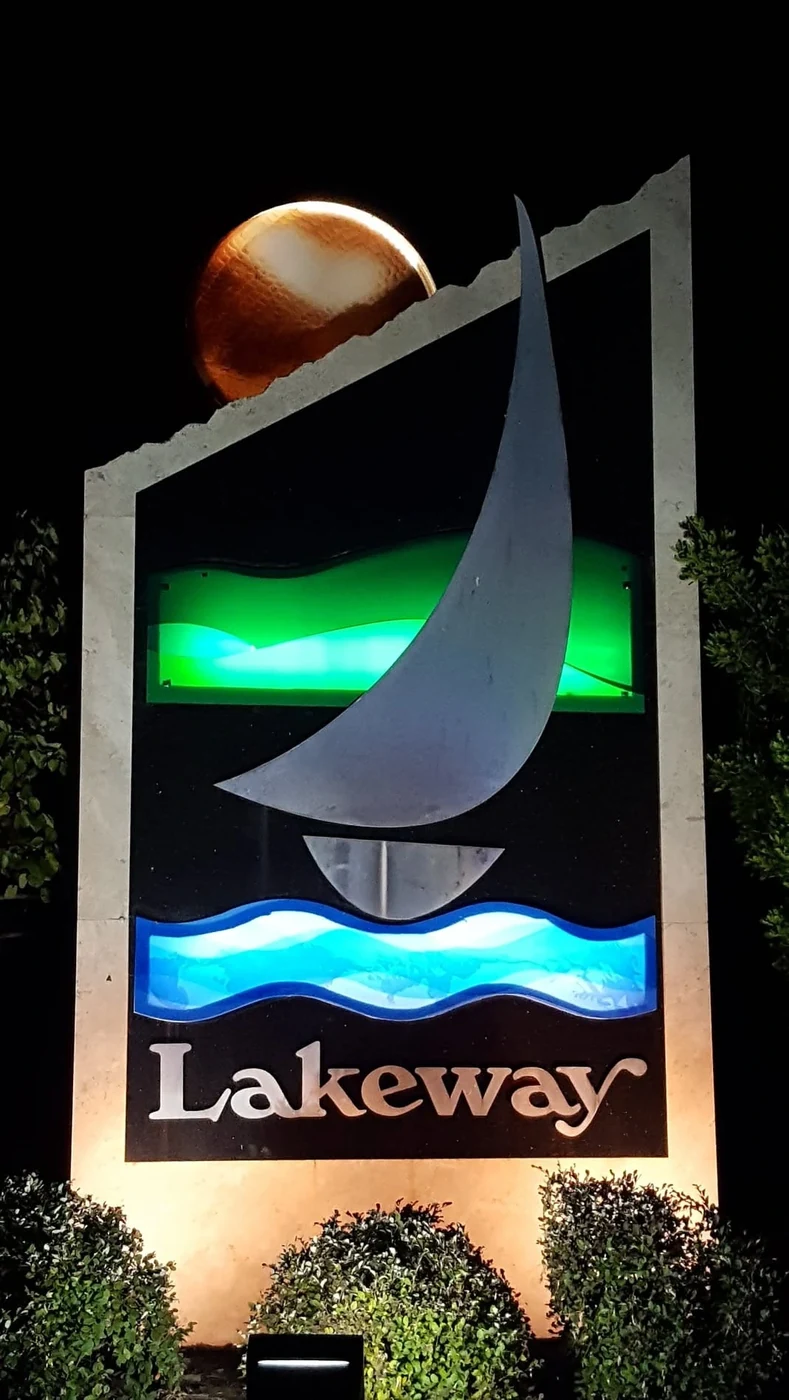 Illuminated monument sign reading Lakeway at night.