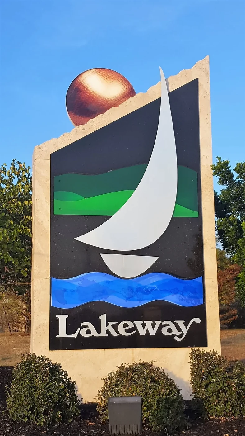 Monument sign reading Lakeway in daylight.