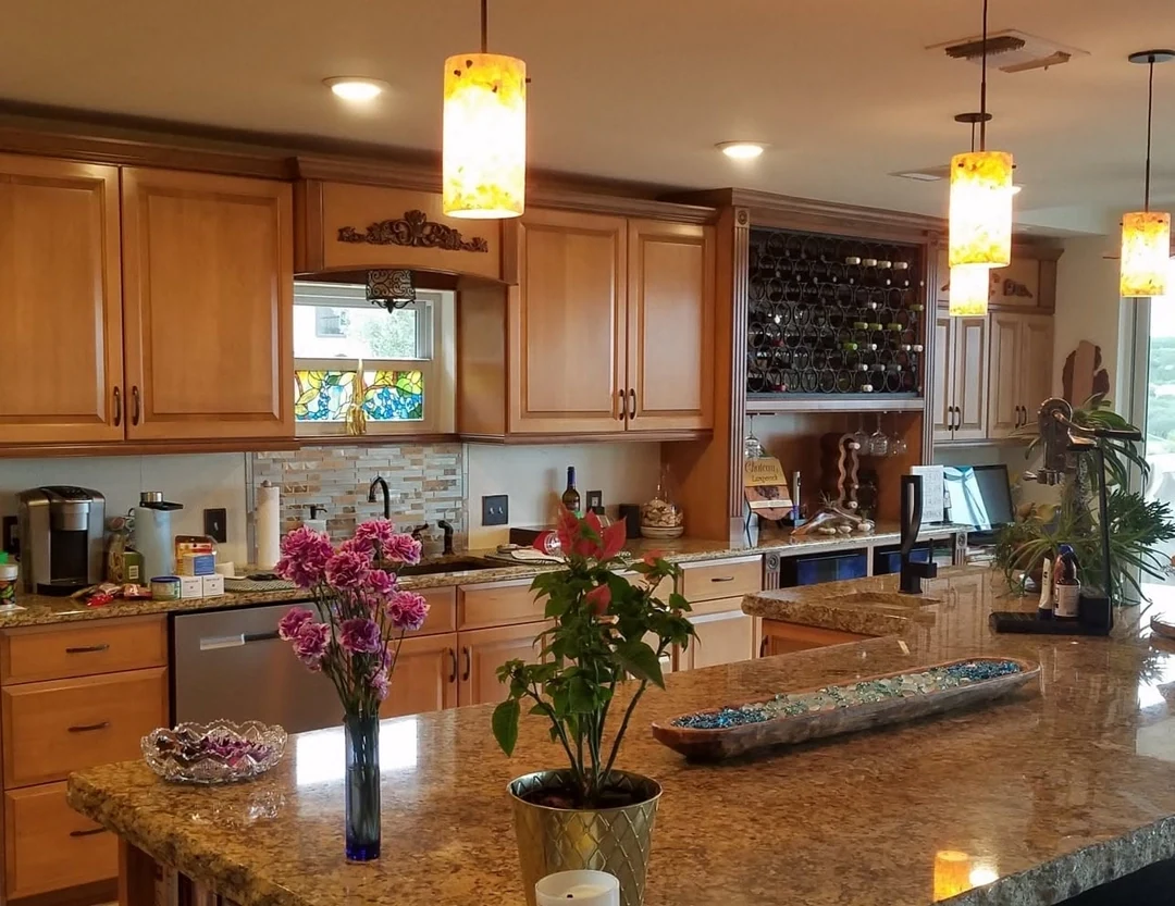 Pendant lights and recessed ceiling lights above a kitchen island.