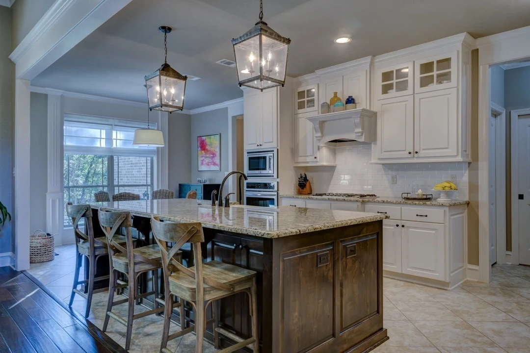 Lantern pendant lights above a kitchen island with white cabinetry.