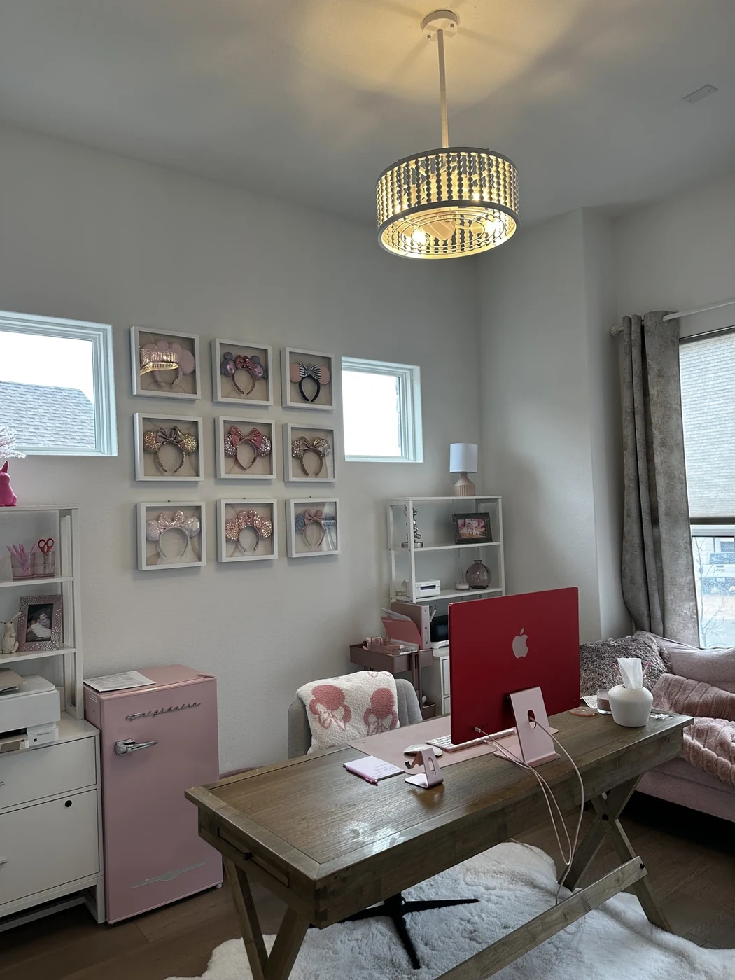 Illuminated pendant light above a desk in a home office.