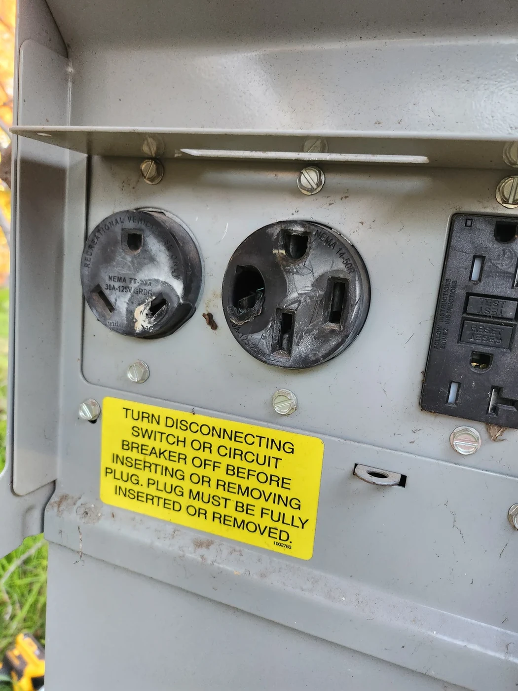 Power receptacles inside an open outdoor electrical enclosure.