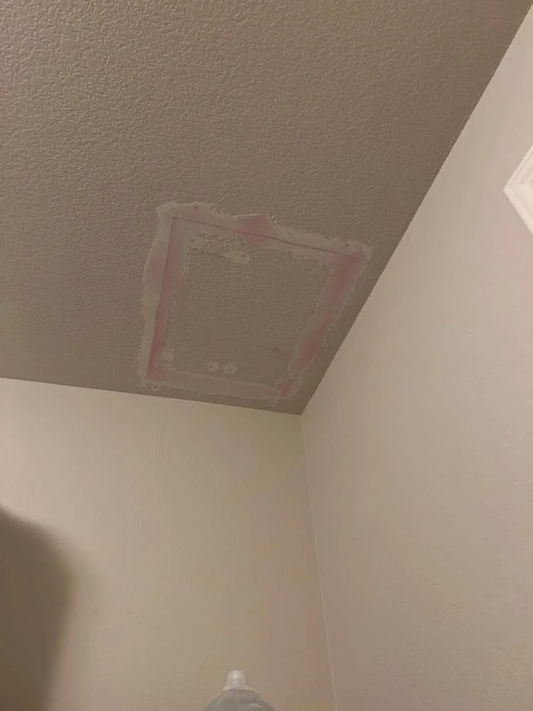 A square patch in a textured ceiling near the corner of a room.