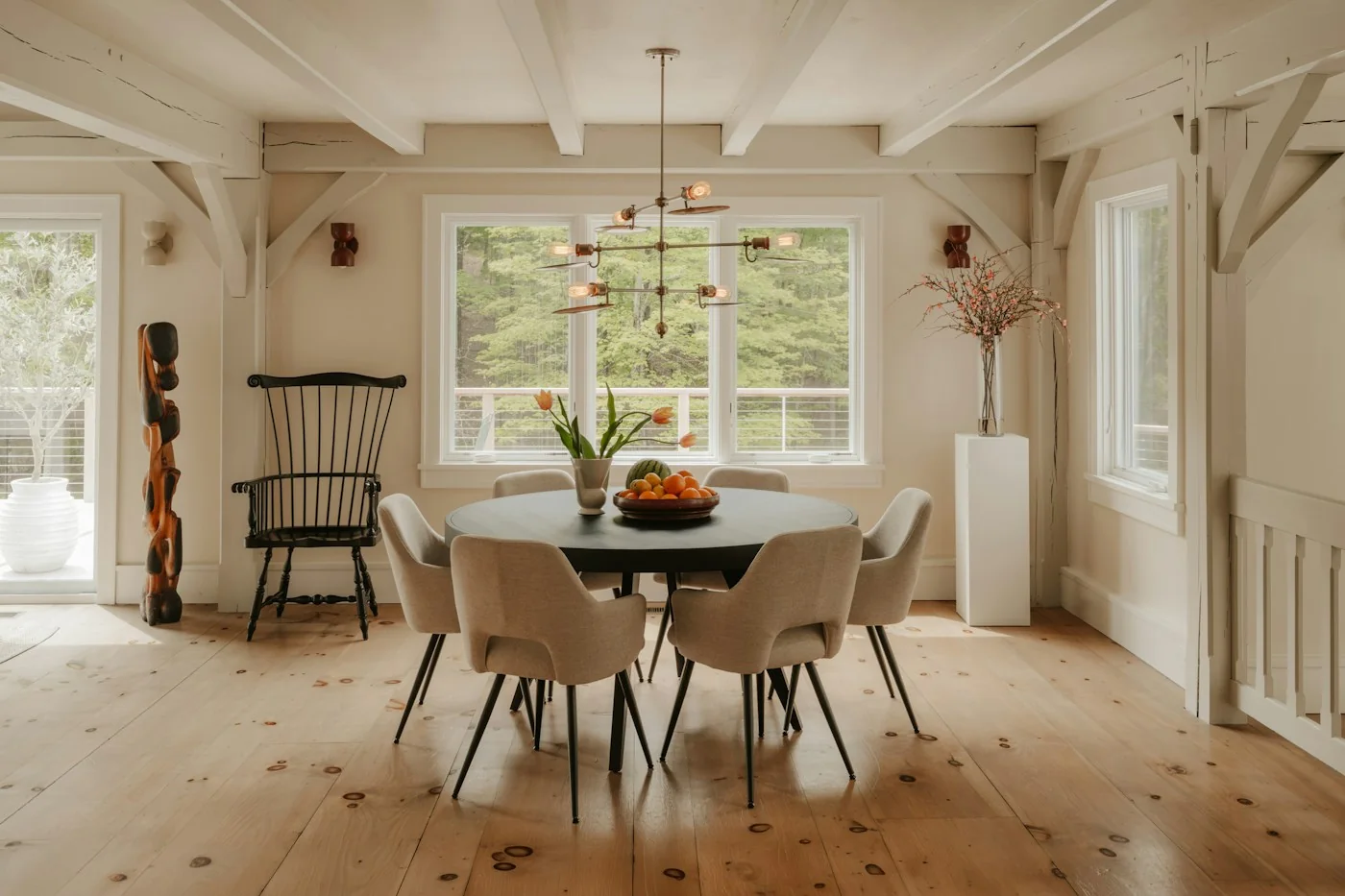 Brass multi-arm chandelier above a round dining table in a bright room